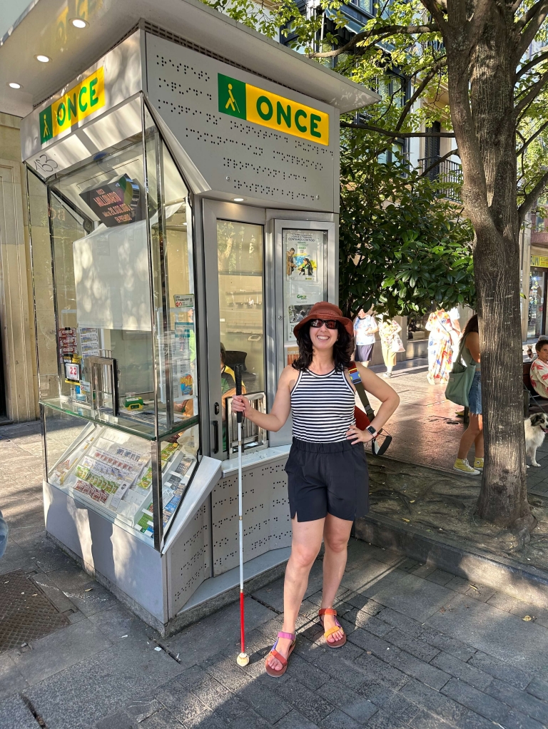 A woman stands outside a kiosk that says "Once" 