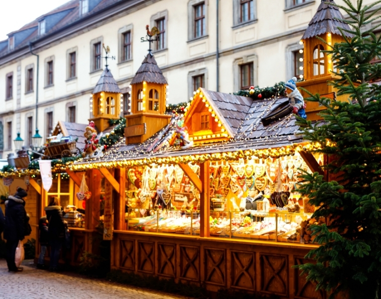 An illuminated market stand selling gingerbread hearts at Dresden's Striezelmarkt