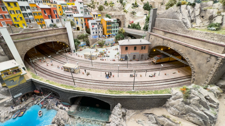 Model train tracks connect two tunnels in a close-up photo of a section of Miniatur Wunderland