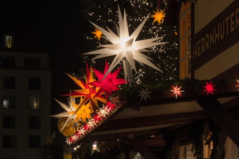 Multi-color stars atop one of the wooden booths at a Dresden Christmas market