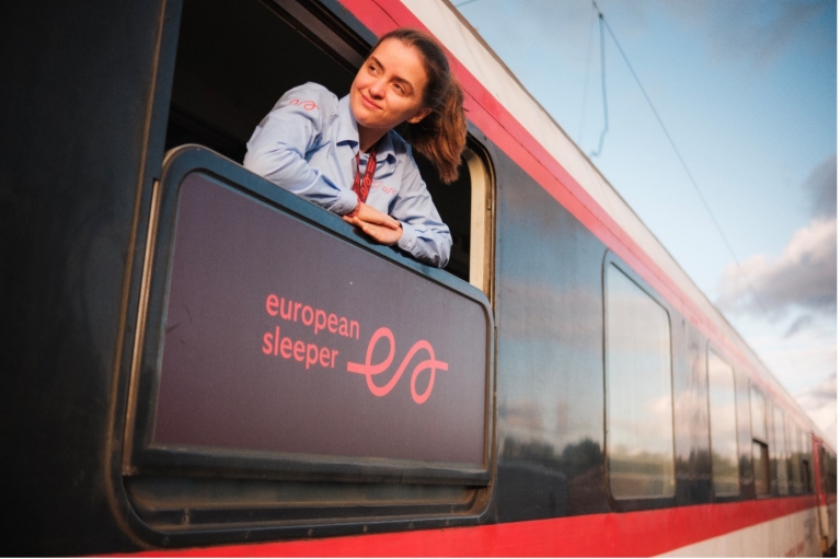 Ragazza che guarda fuori dal finestrino seduta su un treno ESL